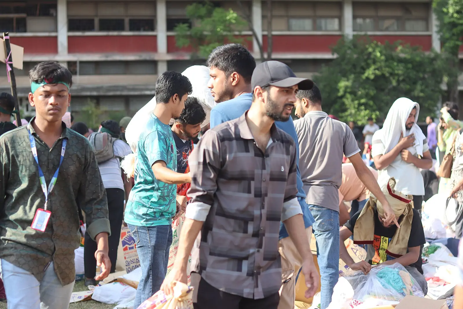 Volunteers sorting and packing sacks of relief supplies for flood-affected families in Bangladesh.